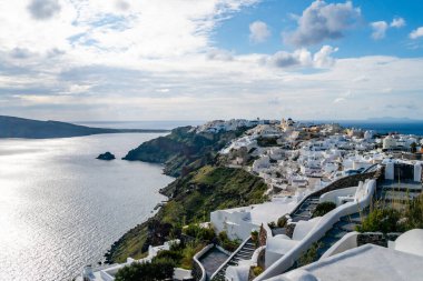 Huzurlu Ege Denizi yakınındaki beyaz evler Santorini 'de bulutlu gökyüzüne karşı