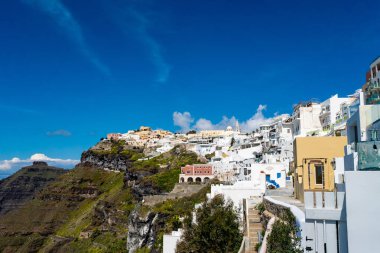  Tepedeki beyaz evler Yunan adasında mavi gökyüzüne karşı 