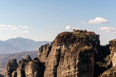 monastery on rock formations near mountains in meteora  clipart