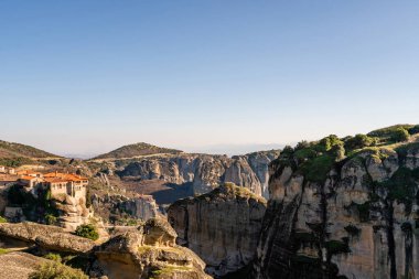 orthodox monastery on rock formations against blue sky in meteora  clipart