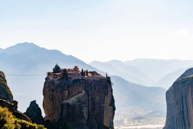 rock formations with orthodox monastery near mountains in meteora  clipart