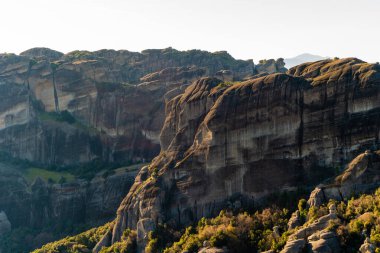 sunshine on rock formations in mountains against sky  clipart