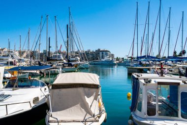 PIRAEUS, GREECE - APRIL 10, 2020: docked yachts in aegean sea against blue sky  clipart