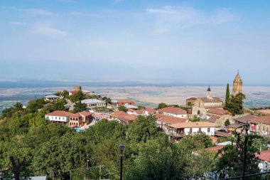Yeşil ağaçların yakınındaki evlerde mavi gökyüzüne karşı güneş ışığı 