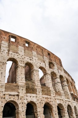ancient Colosseum against cloudy sky in rome  clipart