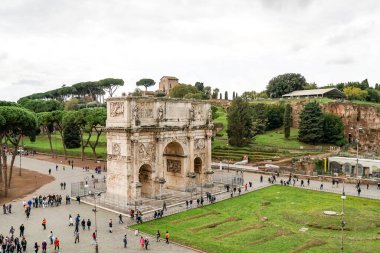 ROME, ITALY - 10 NİSAN 2020: Roma 'daki antik Titus kemerinin yanında yürüyen insanlar