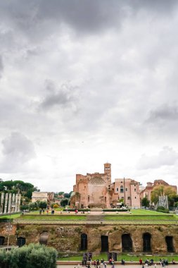 ROME, ITALY - 10 Nisan 2020: Venüs Tapınağı ve Roman harabeleri yakınında yürüyen insanlar 