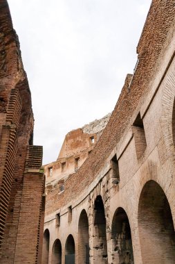 low angle view of ancient and historical colosseum against cloudy sky  clipart