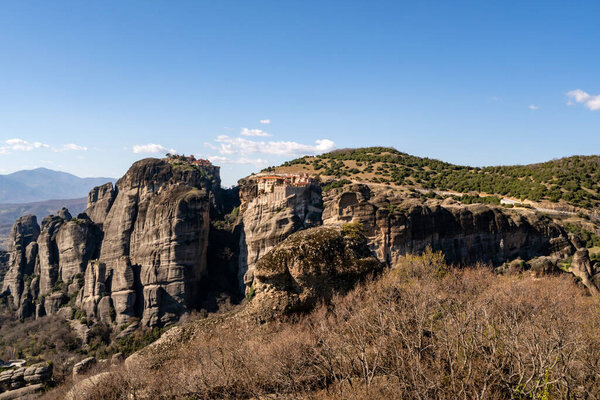 orthodox monastery on rock formations against blue sky in greece