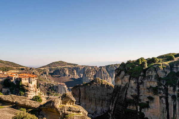 orthodox monastery on rock formations against blue sky in meteora 