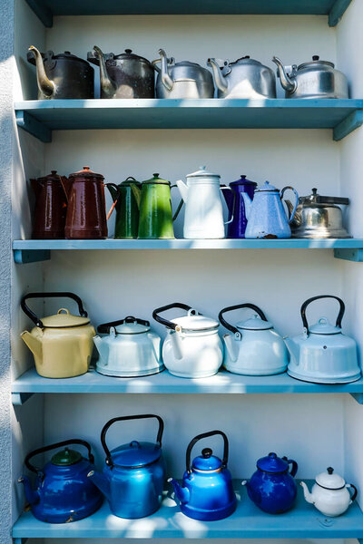sunshine on retro and colorful teapots on shelves 