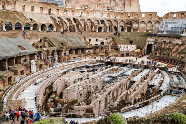 ROME, ITALY - APRIL 10, 2020: people walking near ruins of historical colosseum 