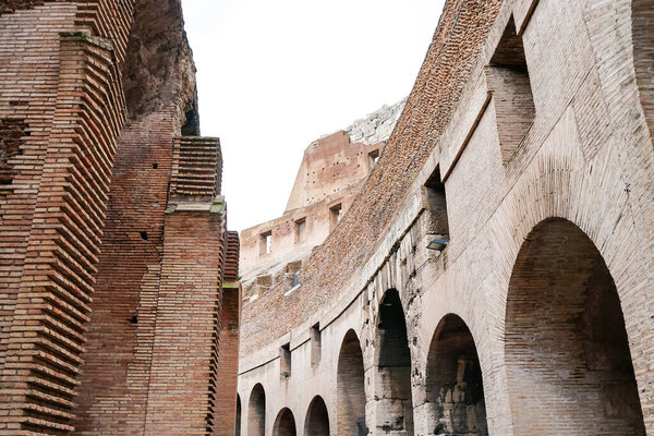 low angle view of historical walls of colosseum against cloudy sky 
