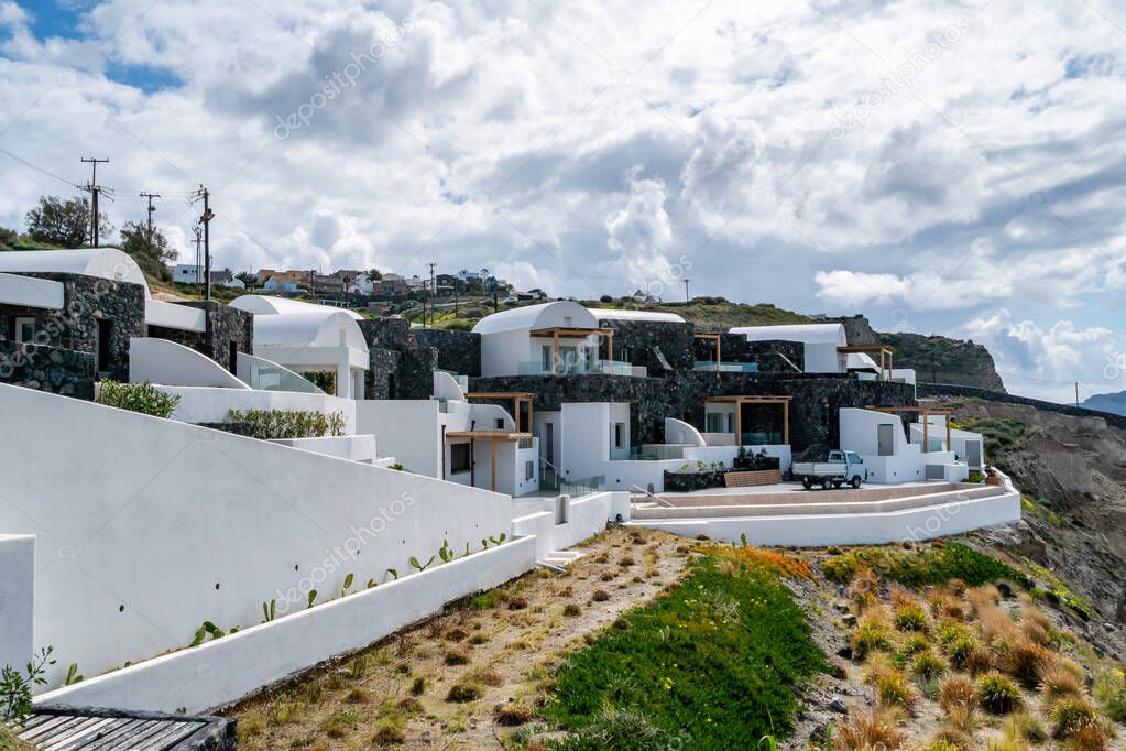  white houses near green plants against sky with clouds 