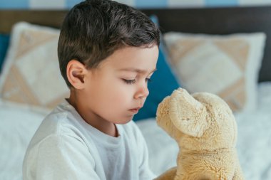 Tatlı çocuk, yumuşak oyuncağa bakıyor. 