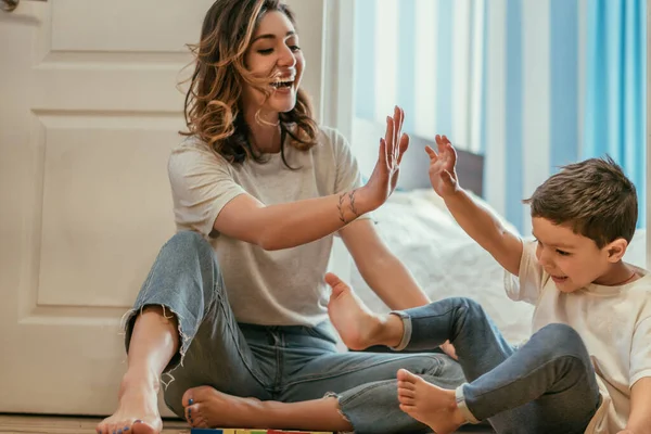 Mutlu Anne Yerde Otururken Çocuğuna Beşlik Çakıyor — Stok fotoğraf