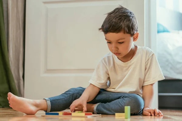 床の上でおもちゃで遊んでかわいい幼児の男の子の選択的な焦点 — ストック写真