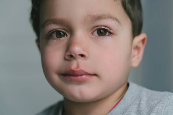 close up of upset toddler boy looking at camera 