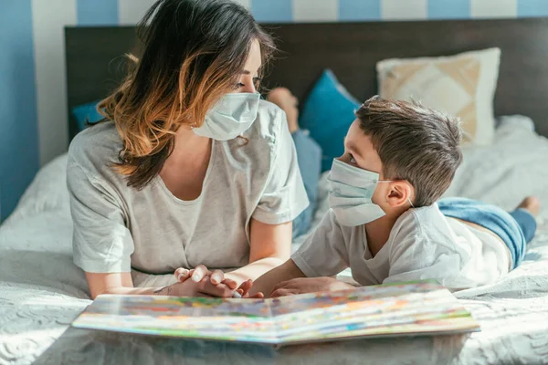 Madre Hijo Pequeño Máscaras Médicas Mirándose Cerca Libro — Foto de Stock