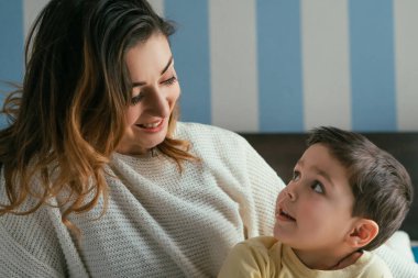Mutlu anne ve güzel oğul yatak odasında birbirlerine bakıyorlar.