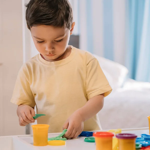 Cute Concentrated Kid Holding Spatula While Sculpting Plasticine Molds Containers — Stock Photo, Image