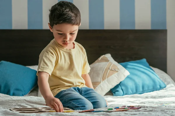 Cute Attentve Kid Playing Board Game While Sitting Bed — Stock Photo, Image