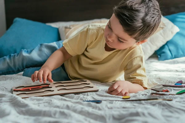 Aufmerksamer Entzückender Junge Beim Brettspiel Mit Puzzles Bett — Stockfoto