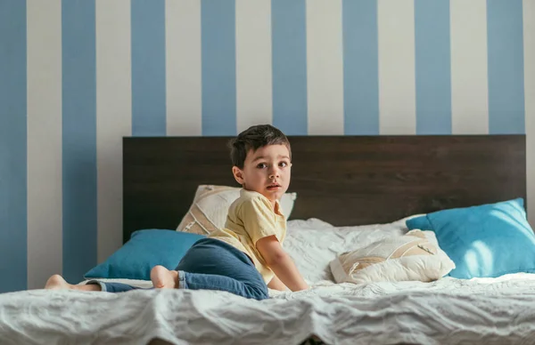 Imádnivaló Fiú Néz Kamera Miközben Mászik Ágyon Otthon — Stock Fotó