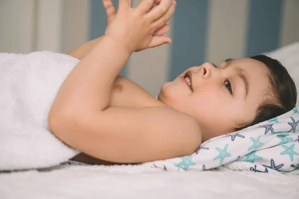 Adorable Smiling Kid Covered Hooded Towel Smiling While Lying Bed — Stock Photo, Image