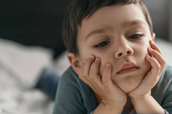 Omtänksam Bedårande Pojke Som Håller Händer Ansiktet När Han Ligger — Stockfoto
