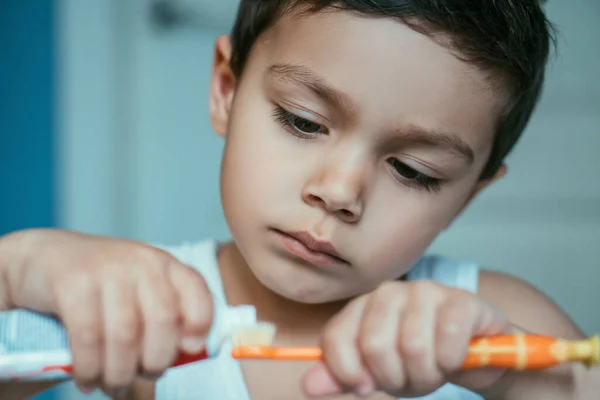 歯ブラシに歯磨き粉を適用する愛らしい少年の選択的焦点 — ストック写真
