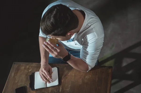 Homem escrevendo em caderno seus planos — Fotografia de Stock