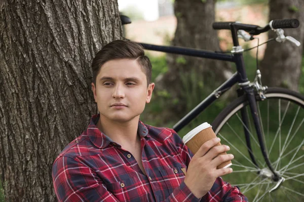 Homme relaxant avec tasse de café au parc — Photo de stock