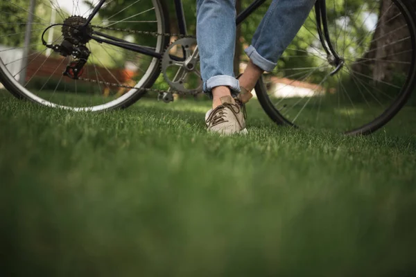 Hombre en jeans con bicicleta - foto de stock