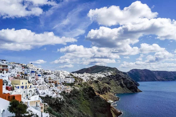 Білі будинки біля спокійного моря на тлі блакитного неба з хмарами в Греції — стокове фото
