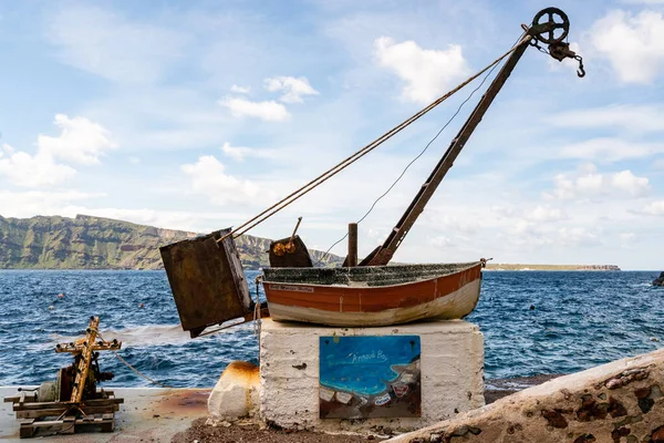 SANTORINI, GRIECHENLAND - 10. APRIL 2020: gealtertes und rostiges Boot mit Glocke in Meeresnähe auf griechischer Insel — Stockfoto