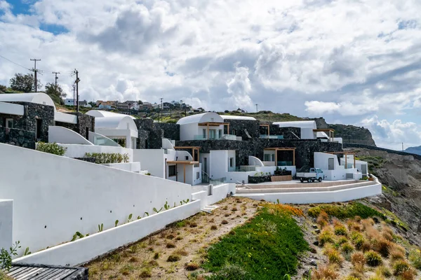 Weiße Häuser in der Nähe grüner Pflanzen gegen wolkenverhangenen Himmel — Stockfoto