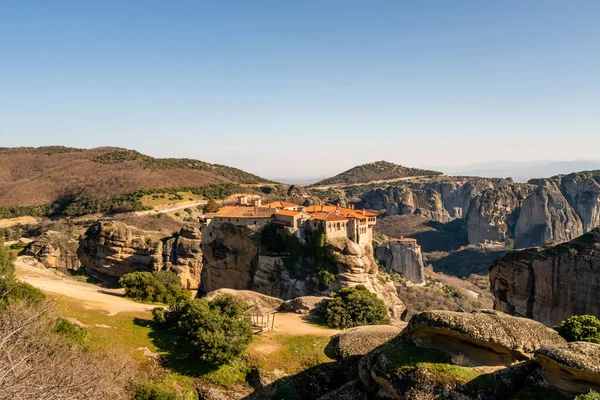 Sole su monastero storico su formazioni rocciose in meteora — Foto stock