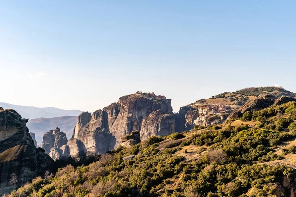 Rock formations with monastery near mountains in meteora — Stock Photo