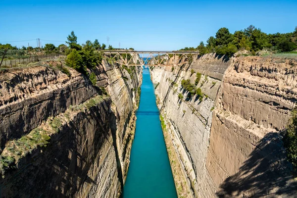 Blue water flowing near rocky hills with bridge — Stock Photo