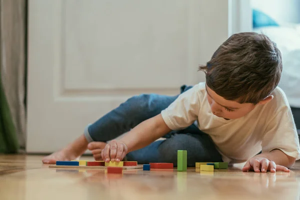 Selektiver Fokus des niedlichen Kleinkindes, das mit Spielzeug auf dem Boden spielt — Stockfoto