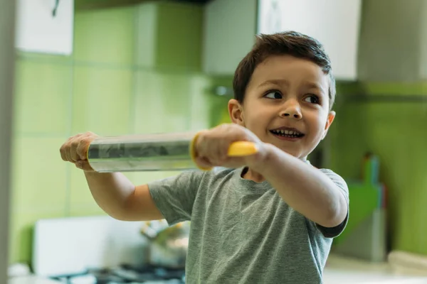 Foyer sélectif de garçon heureux tout-petit tenant rouleau à pâtisserie — Photo de stock