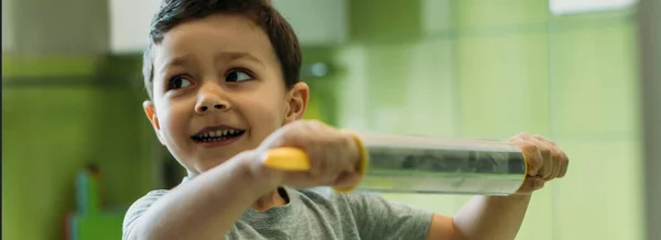 Panoramic crop of cute toddler boy holding rolling pin — Stock Photo