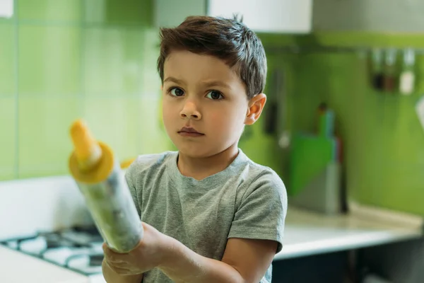 Selective focus of adorable toddler boy holding rolling pin — Stock Photo