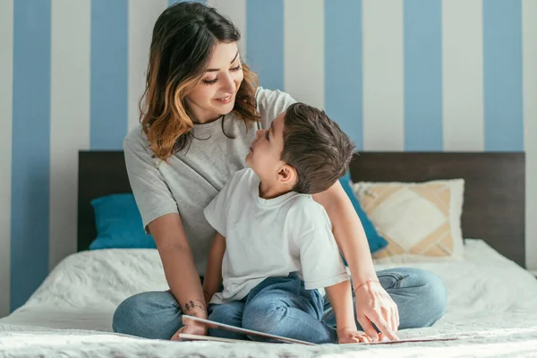 Madre felice e figlio bambino carino guardando l'un l'altro in camera da letto — Foto stock