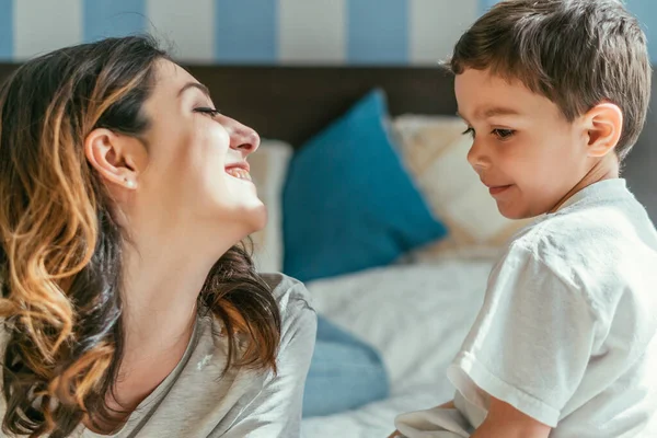 Cheerful mother looking at cute toddler son — Stock Photo