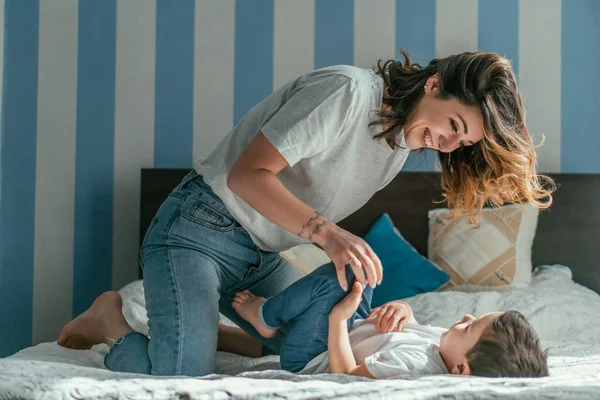 Mãe alegre brincando com filho no quarto — Fotografia de Stock
