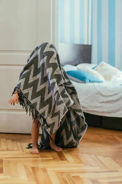 Little barefoot boy covered with blanket standing near bedroom — Stock Photo