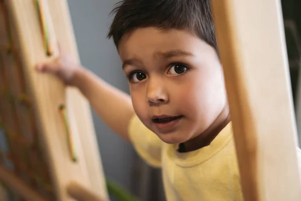 Enfoque selectivo de niño adorable subir en escalera en el gimnasio en casa - foto de stock