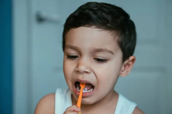 Mignon, diligent garçon brossant les dents dans la salle de bain — Photo de stock